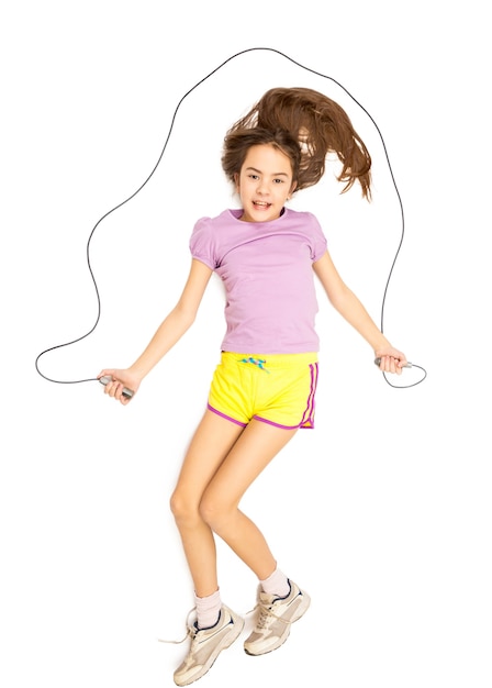 Isolated photo of cute smiling girl jumping with skipping rope