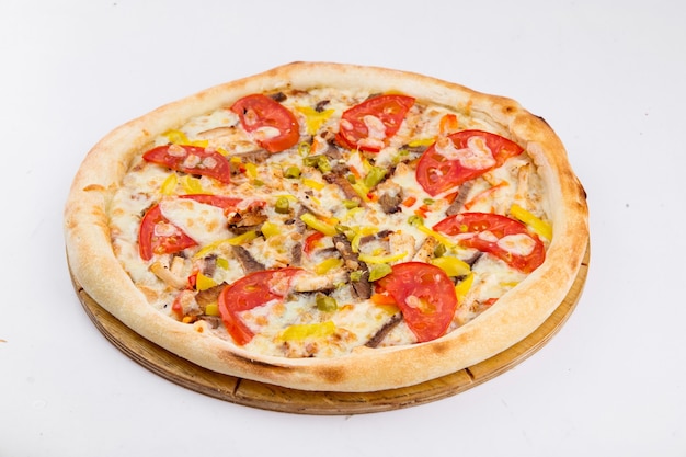 Isolated pizza with meat and tomato on a wooden board