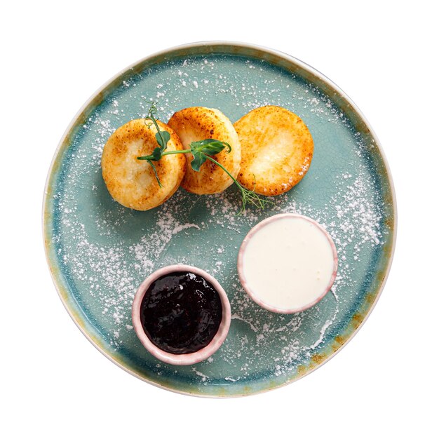 isolated plate of cottage cheese pancakes syrniki