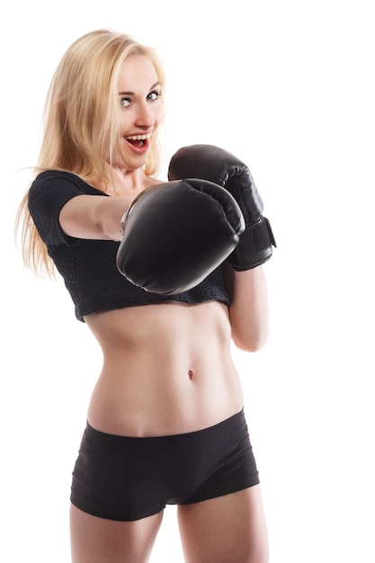 Photo isolated portrait of athletic asian woman in black boxing gloves slim athletic girl in training clothes looking at camera vertical concept photo of sport boxing victory rivalry theme