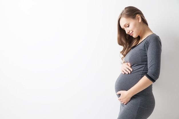 Photo isolated portrait of beautiful smiling woman in dress waiting for baby