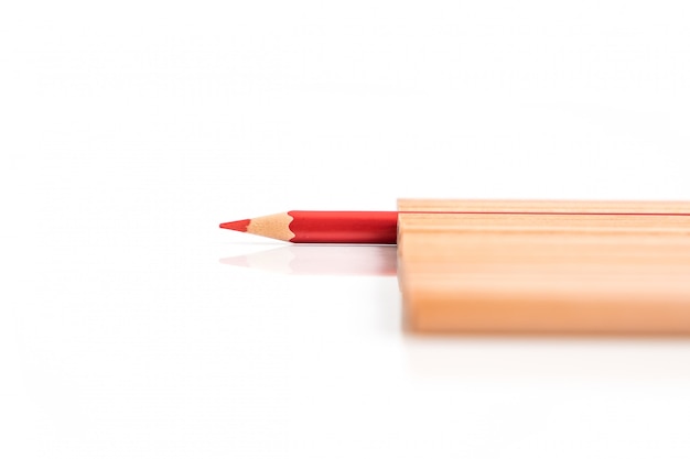 Isolated red colored pencil stand out of other brown pencils