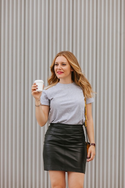 Isolated sexy  woman drinking coffee walking on the street