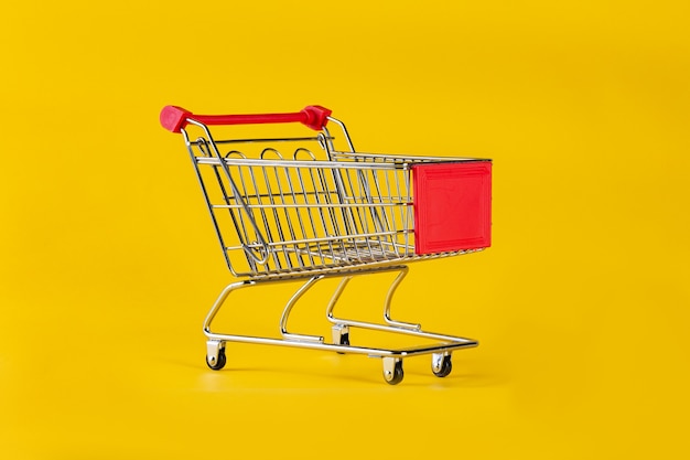 Isolated shopping cart on yellow background.