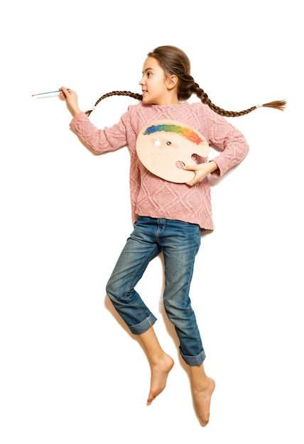 Isolated shot of cute girl with braids drawing picture with oil paints