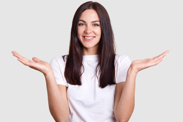 Isolated shot of joyful brunette pretty woman laughing happily