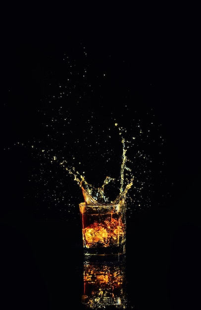 Isolated shot of whiskey with splash on black background