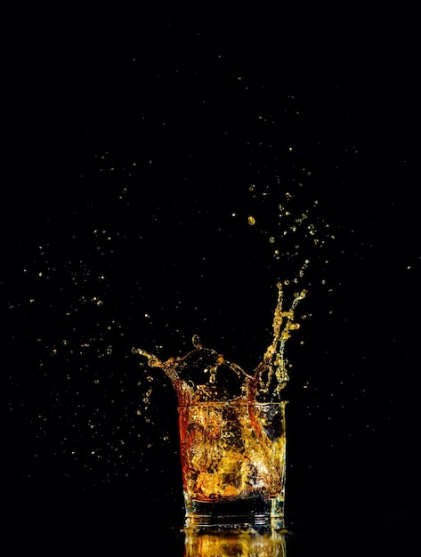 Isolated shot of whiskey with splash on black background