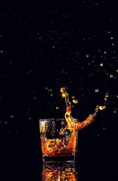 Isolated shot of whiskey with splash on black background