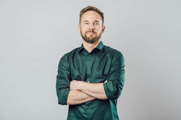 Isolated shot of young handsome male with beard over gray