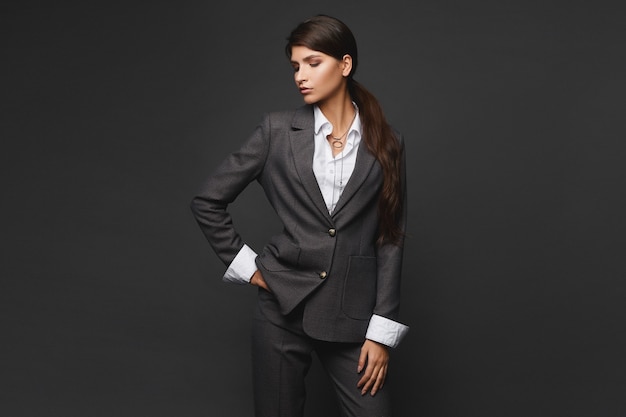 Isolated studio portrait of a confident businesswoman in a grey stylish suit