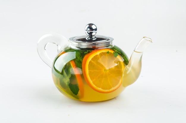 Photo isolated teapot of green tea with orange and mint