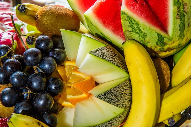 Foto fette di frutti tropicali isolati. frutta esotica fresca tagliata a metà (maracuya, kiwi, mangostano, ananas, dragonfruit) in una riga isolata su sfondo bianco con tracciato di ritaglio