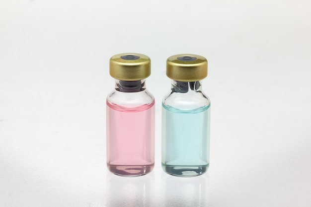 Isolated two glass vaccine bottles with different colored liquid very close high magnification mockup