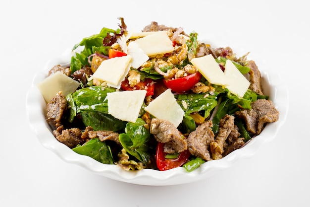 Isolated warm salad with veal and nuts