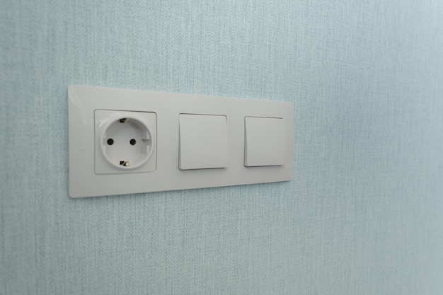 Isolated white beige switch and socket on a light wall aesthetics of electrics repair security interior design place for text