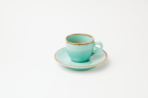 Isolated on white shot of a turquoise cup and saucer with a little espresso