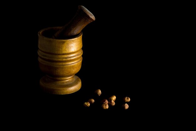 Isolated wooden pestle and mortar with hazelnuts