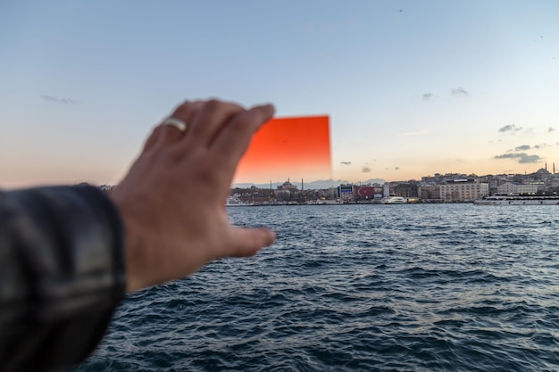 Стамбул Турция 04 декабря 2015 г. Различия между использованием красного фильтра или не использованием над силуэтом Стамбула с размытой рукой