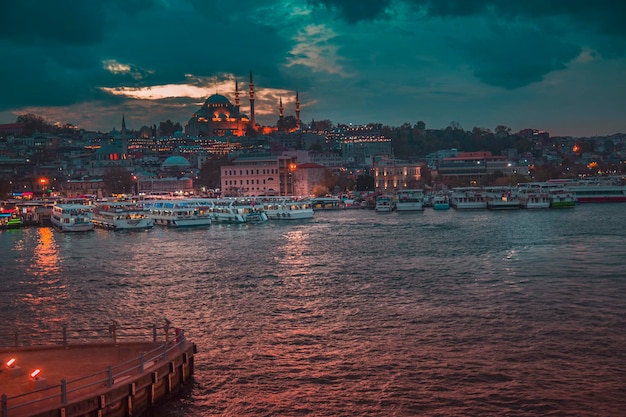 Istanbul Turkey November 30 2019 Moody illuminated ferry and Galata Tower during twilight