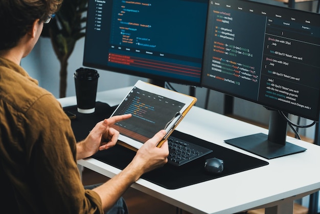 IT developer working online software development coding on pc screens Gusher