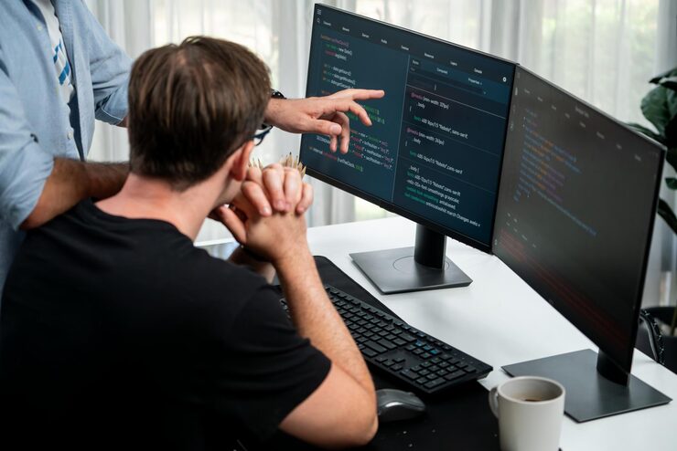 Photo it developers discussing online software development information on pc screen creating program coding for latest version application on website concept of brainstorming firmware updated sellable