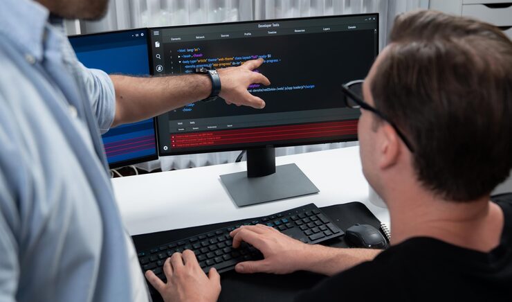 Photo it developers pointing on software development information on two screens with coding program in application and website technical engineer coder analyzing in safety program concept sellable