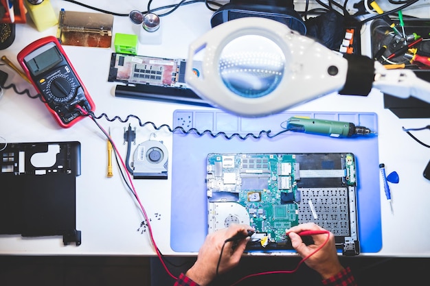 IT engineer technician repairing computer component in electronics service and maintenance shop
