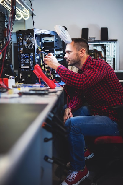 ИТ-инженер ремонтирует компьютерный компонент в мастерской по ремонту и обслуживанию электроники
