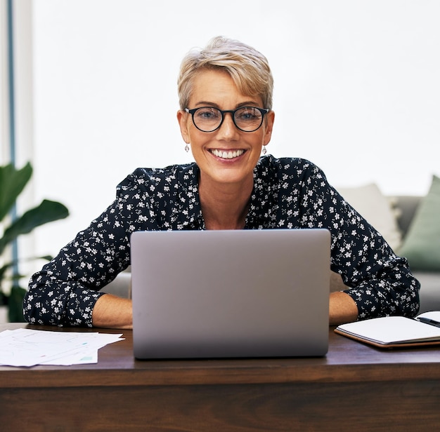 Do it from home if you must. Shot of a mature woman using her laptop while working from home.