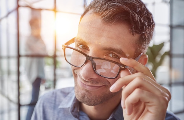 It guy adjusting glasses in a modern new office