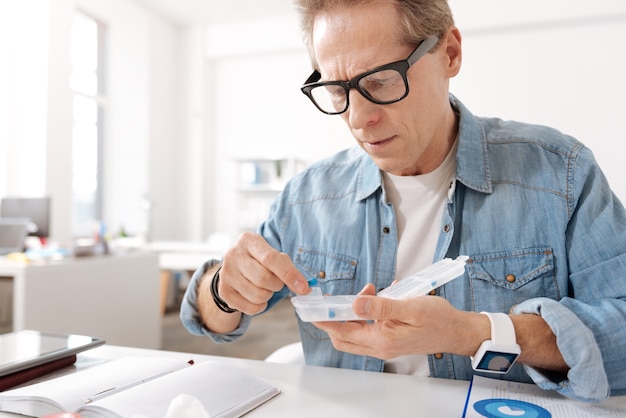 Viene dalla rinite. uomo concentrato che indossa una camicia di jeans, corrugando la fronte mentre tiene la bocca aperta