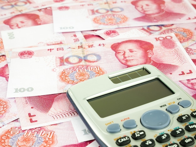 It is a lot of One hundred Yuan banknotes pile background with Calculator