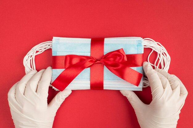 it is time to share presents concept. top above pov first person overhead close up view photo of hands in protective latex gloves preparing surprise isolated bright background