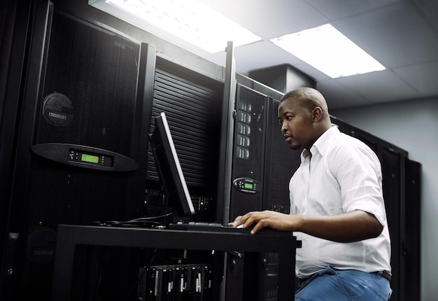 IT-ondersteuning zwarte man of codering op laptop in serverruimte voor big data-netwerkglitch of digitale website Codebepaling of technicus typen op computertesten UX-programmering of softwareontwikkeling