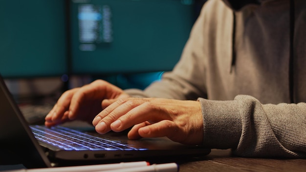 It programmer hacking security server on computer, using
development malware to steal big data from system. working at night
with multiple monitors to hack important information. close
up.