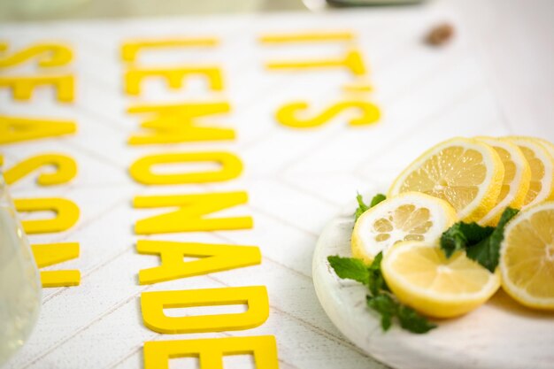 Foto È l'insegna in legno della stagione della limonata con un bicchiere di limonata fresca.