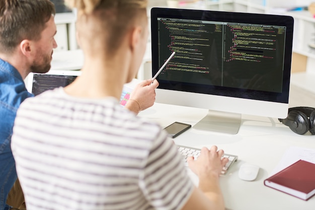 IT specialists viewing computer code