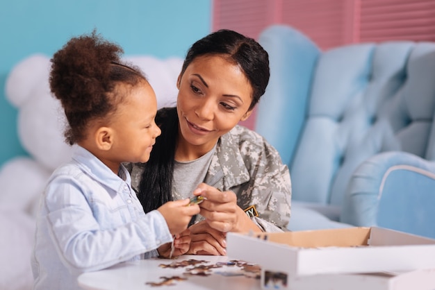 It will match yours. Charming lovely stunning woman helping her daughter completing a beautiful picture while enjoying her staying at home during the weekend