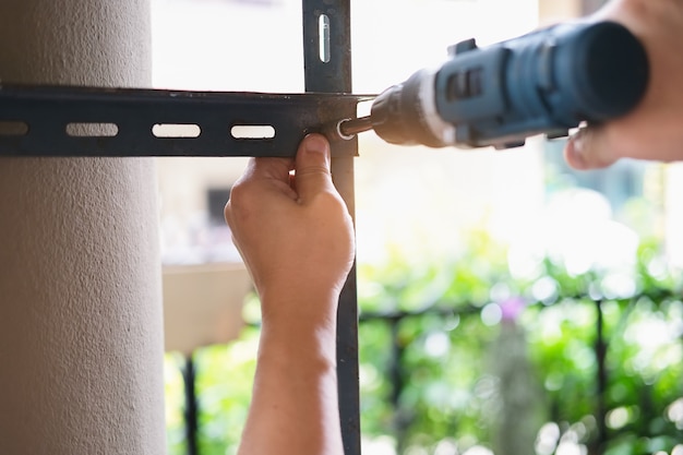 Do it yourself concept, Craftsmen use electric drills to assemble old iron parts. Make a shelf on your free weekend.