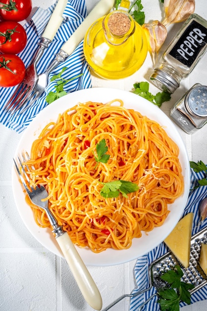 Italiaans mediterraan lunchconcept Spaghetti-pasta met marinara-tomatensaus Op een witte tegeltafel met kruiden voor het diner kopieerruimte