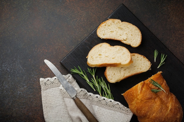 Italiaans traditioneel Ciabatta-brood met rozemarijn op een donkere betonnen ondergrond