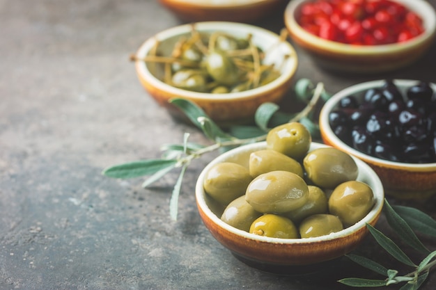 Italiaans voorgerecht van bovenaf. Mediterraan snackassortiment. Zwarte en groene olijven, kappertjes, olijfolie, ui en peper.