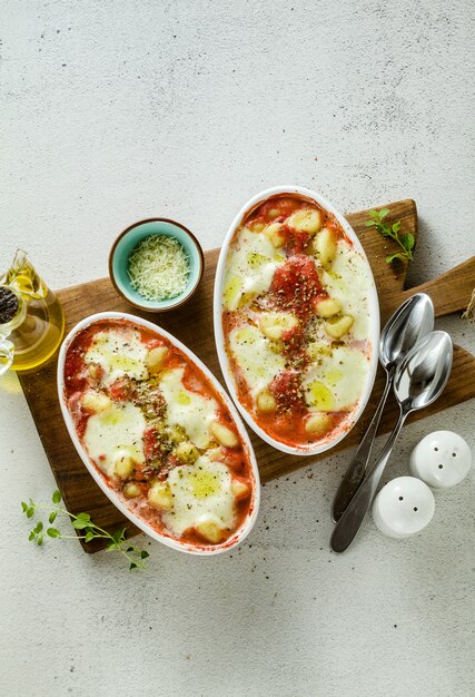 Italiaanse aardappel knoedels gnocchi alla sorrentina met mozzarella kaas, gebakken in de oven met tomatensaus en kruiden.