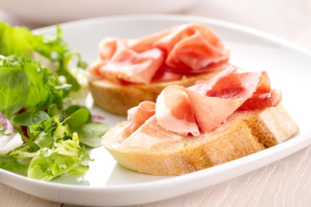 Italiaanse amuse bruschetta met Parmaham op een bord