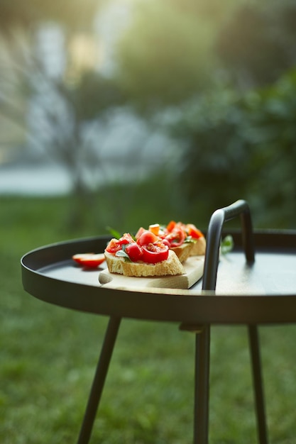 Italiaanse bruschetta met verse rode tomaten en basilicumkruiden op een houten plank buiten