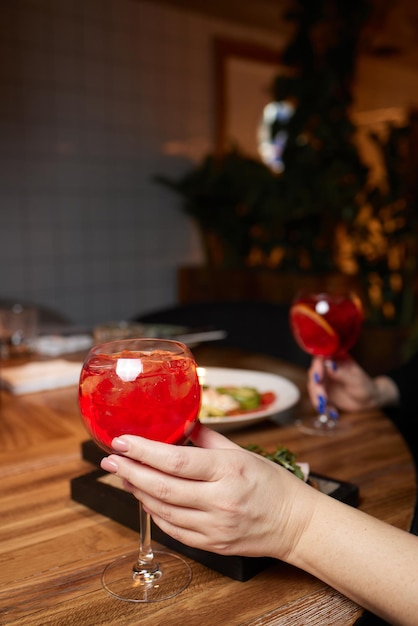 Italiaanse cocktail met stukjes sinaasappel op grijze stenen tafel. Zomerdrankje, huisgemaakt.