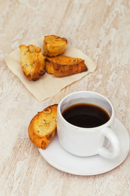 Italiaanse droge eigengemaakte koekjes cantucci op lijst en koffie in witte kop.