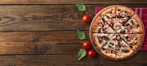 Italiaanse gesmolten kaaspizza op een zwarte tafel met voedselingrediënten, cherrytomaatjes en rozemarijn C