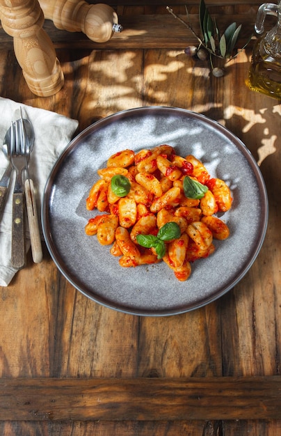 Italiaanse Gnocchi met tomatensaus en basilicum op houten achtergrond